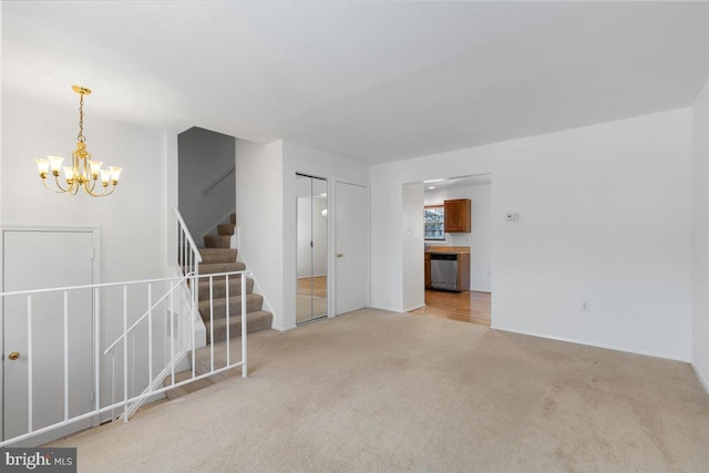 empty room featuring a notable chandelier and light carpet