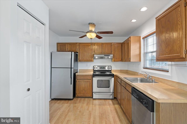 kitchen with sink, appliances with stainless steel finishes, light wood-type flooring, and ceiling fan