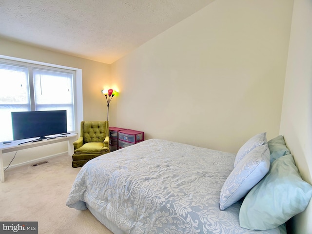 carpeted bedroom featuring a textured ceiling and lofted ceiling