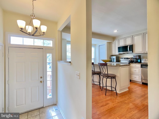 entryway featuring light hardwood / wood-style flooring and a chandelier