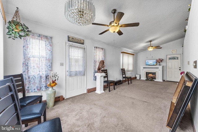 interior space with a fireplace with flush hearth, carpet flooring, vaulted ceiling, and a textured ceiling