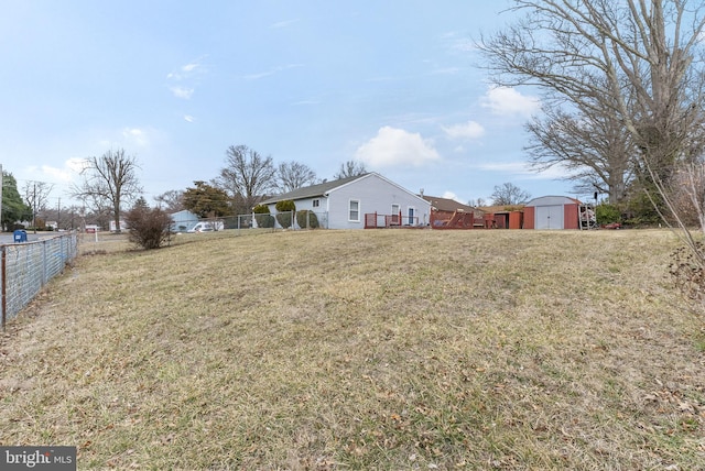 view of yard featuring an outdoor structure, a storage shed, and fence