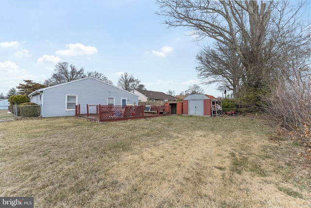 view of yard featuring fence, a storage unit, and an outdoor structure