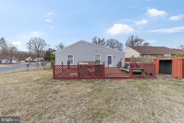 rear view of house featuring a deck, a lawn, and fence