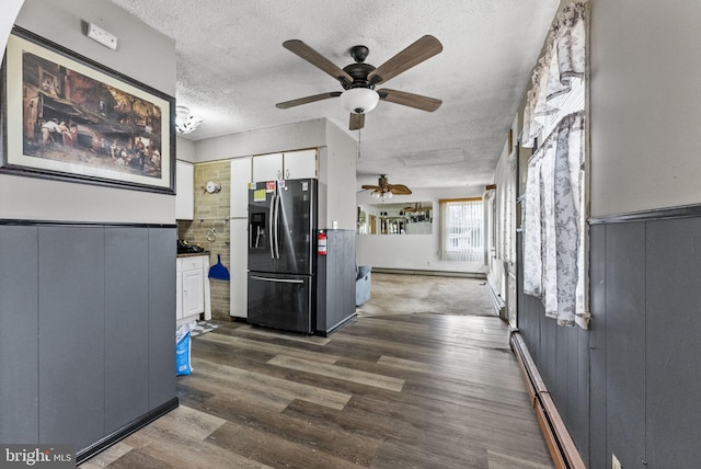 kitchen featuring a textured ceiling, dark wood-style flooring, white cabinets, and stainless steel fridge with ice dispenser