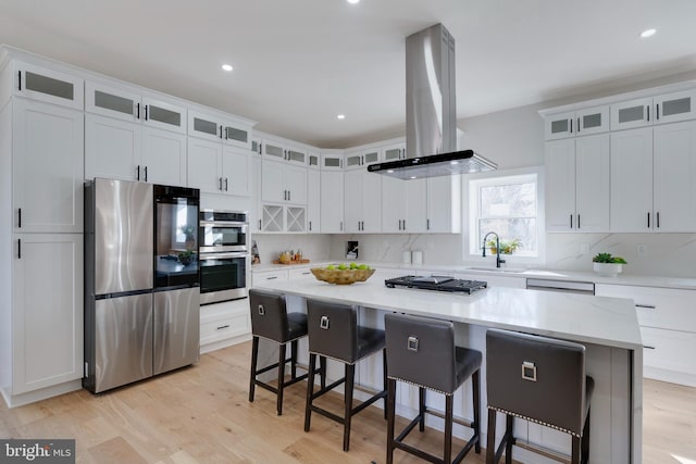 kitchen featuring white cabinetry, island range hood, a center island, and stainless steel appliances