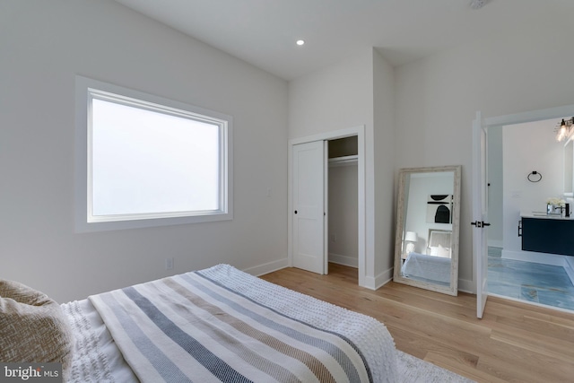 bedroom with light hardwood / wood-style floors and a closet