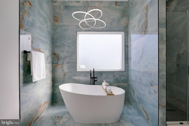 bathroom featuring tile walls and a bath