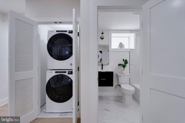 washroom featuring sink and stacked washing maching and dryer