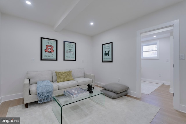 living room with beamed ceiling and light hardwood / wood-style flooring