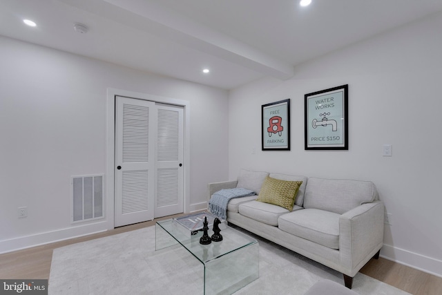 living room with beamed ceiling and light hardwood / wood-style floors