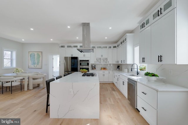 kitchen with a kitchen island, sink, white cabinets, and appliances with stainless steel finishes