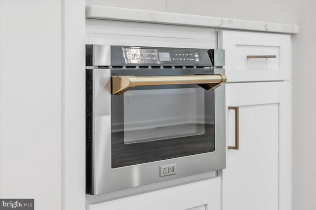 details with white cabinetry and stainless steel oven