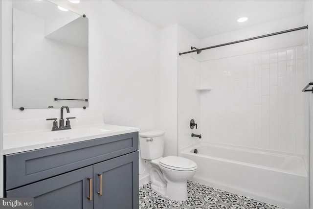 full bathroom featuring toilet, vanity, tiled shower / bath, and tile patterned flooring