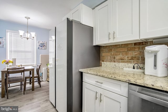 kitchen with white cabinetry, hanging light fixtures, a notable chandelier, light stone countertops, and light hardwood / wood-style flooring