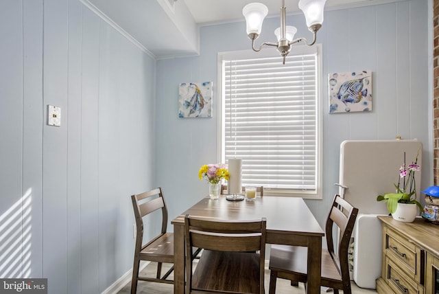 dining space with an inviting chandelier and ornamental molding