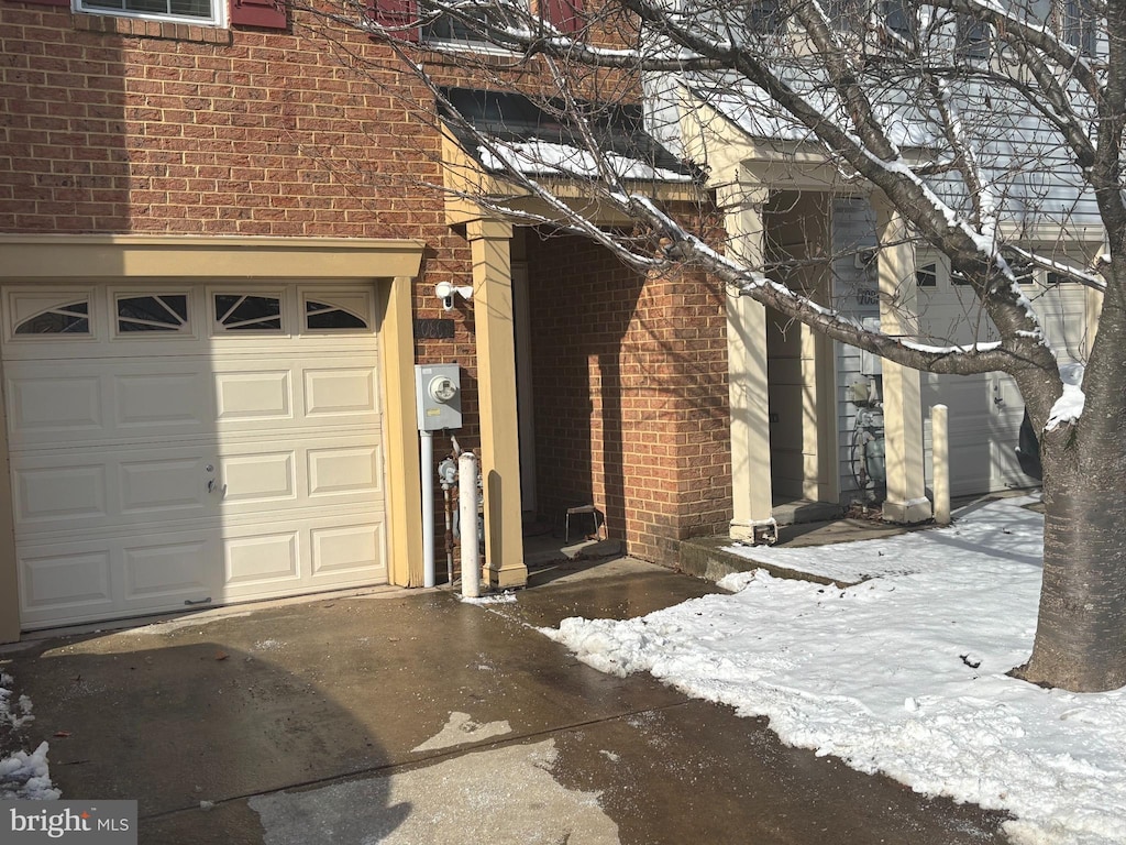 view of snowy exterior featuring a garage