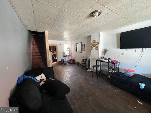 living room featuring a drop ceiling and dark hardwood / wood-style floors