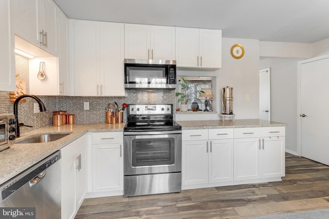 kitchen with sink, white cabinetry, decorative backsplash, and appliances with stainless steel finishes