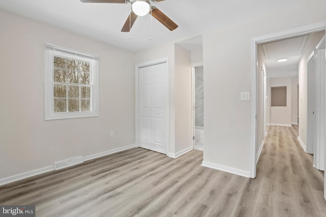 unfurnished bedroom with light hardwood / wood-style floors, ceiling fan, and a closet