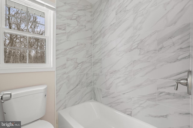 bathroom featuring tiled shower / bath and toilet