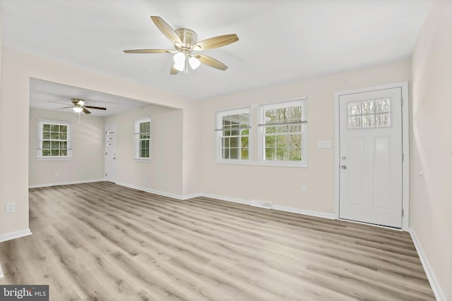 interior space with ceiling fan, a healthy amount of sunlight, and light wood-type flooring