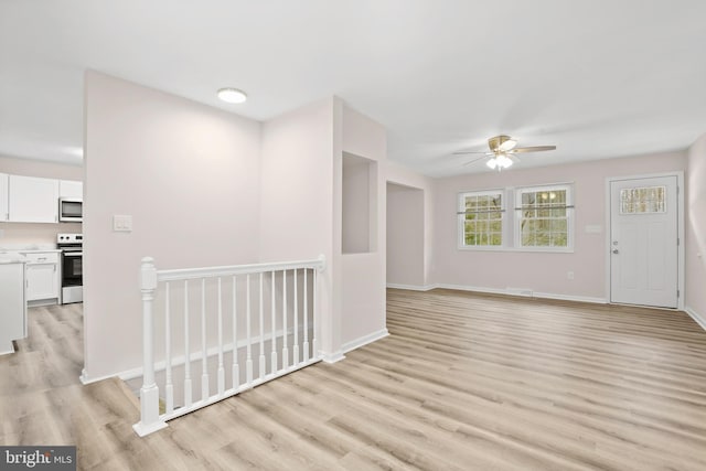 unfurnished living room with ceiling fan and light hardwood / wood-style flooring