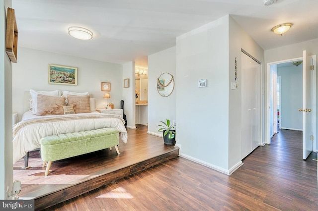 bedroom featuring dark wood-type flooring and ensuite bathroom