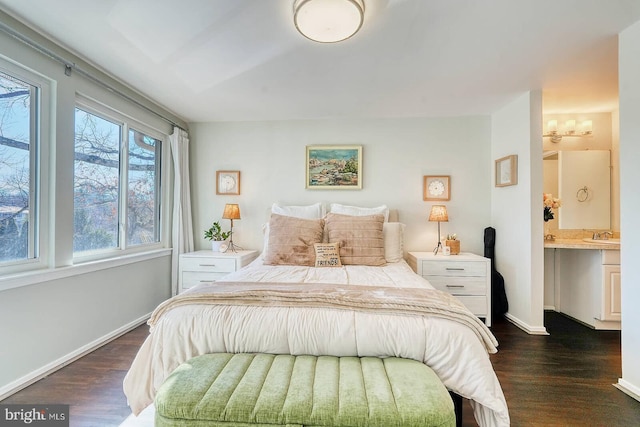 bedroom with dark wood-type flooring and connected bathroom