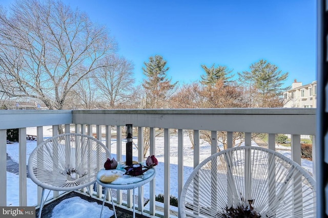 view of snow covered back of property