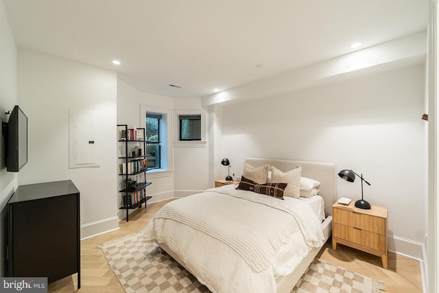 bedroom featuring electric panel and light parquet flooring