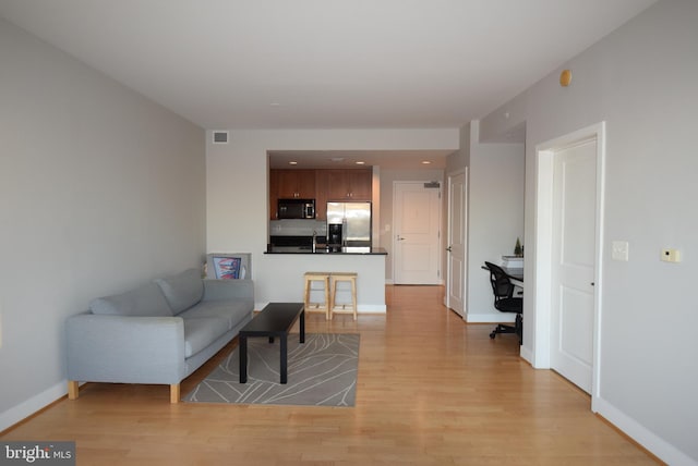 living room featuring light hardwood / wood-style floors and sink