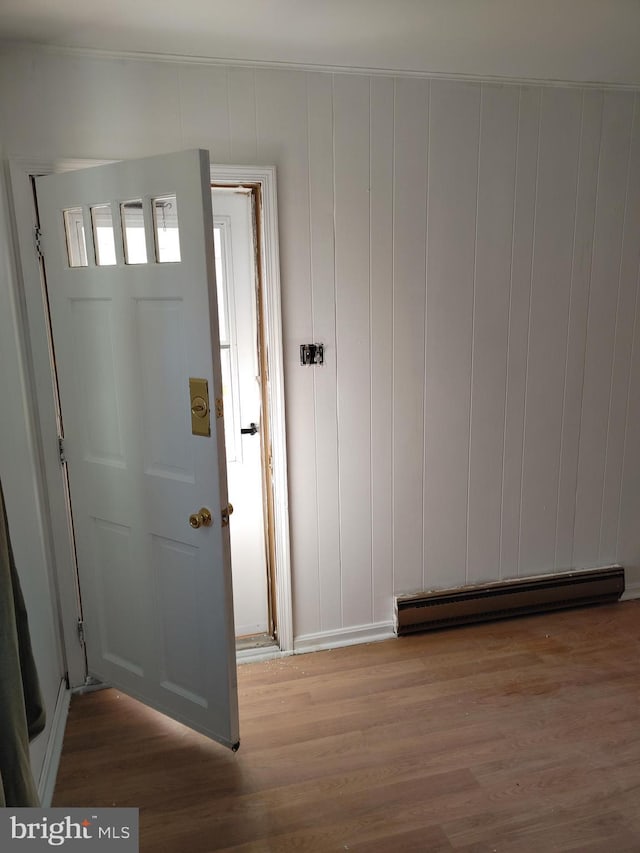 foyer entrance featuring wood-type flooring and a baseboard radiator