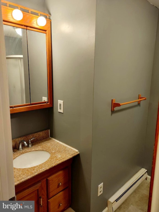 bathroom featuring baseboard heating and vanity