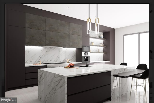 kitchen with stainless steel gas stovetop, an island with sink, decorative backsplash, hanging light fixtures, and sink