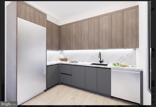 kitchen with gray cabinets, tasteful backsplash, stainless steel dishwasher, light hardwood / wood-style flooring, and sink