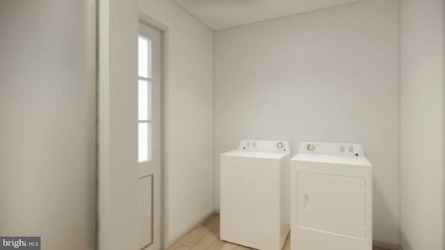 washroom with washing machine and clothes dryer and light hardwood / wood-style flooring