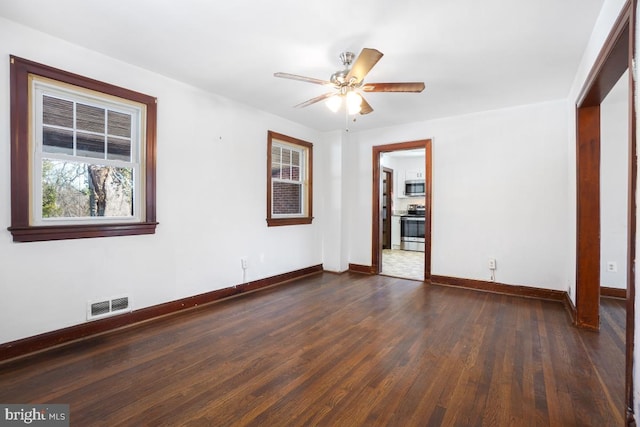 spare room with ceiling fan and dark wood-type flooring