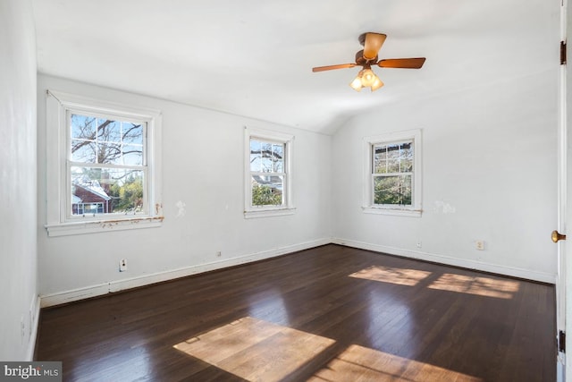 empty room featuring ceiling fan, plenty of natural light, dark hardwood / wood-style floors, and lofted ceiling