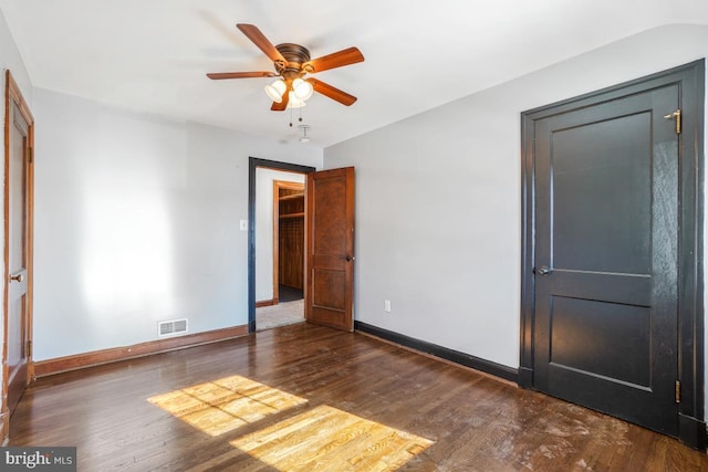 unfurnished bedroom with ceiling fan and dark wood-type flooring