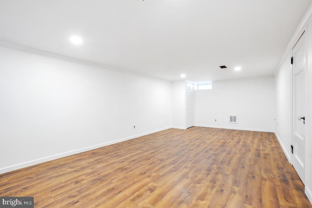 basement featuring ornamental molding and hardwood / wood-style flooring