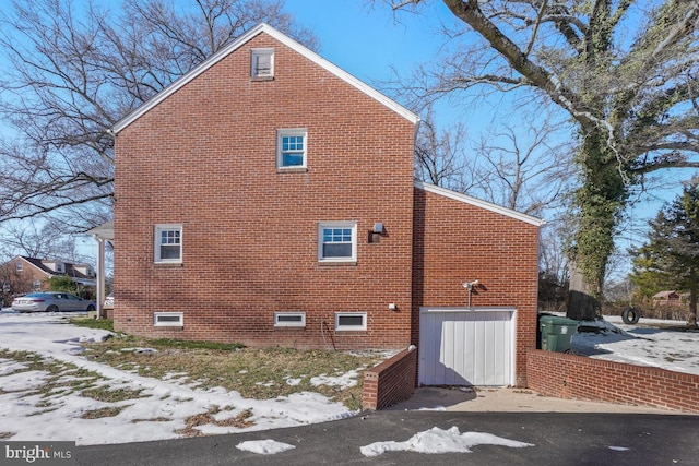 snow covered property with a garage