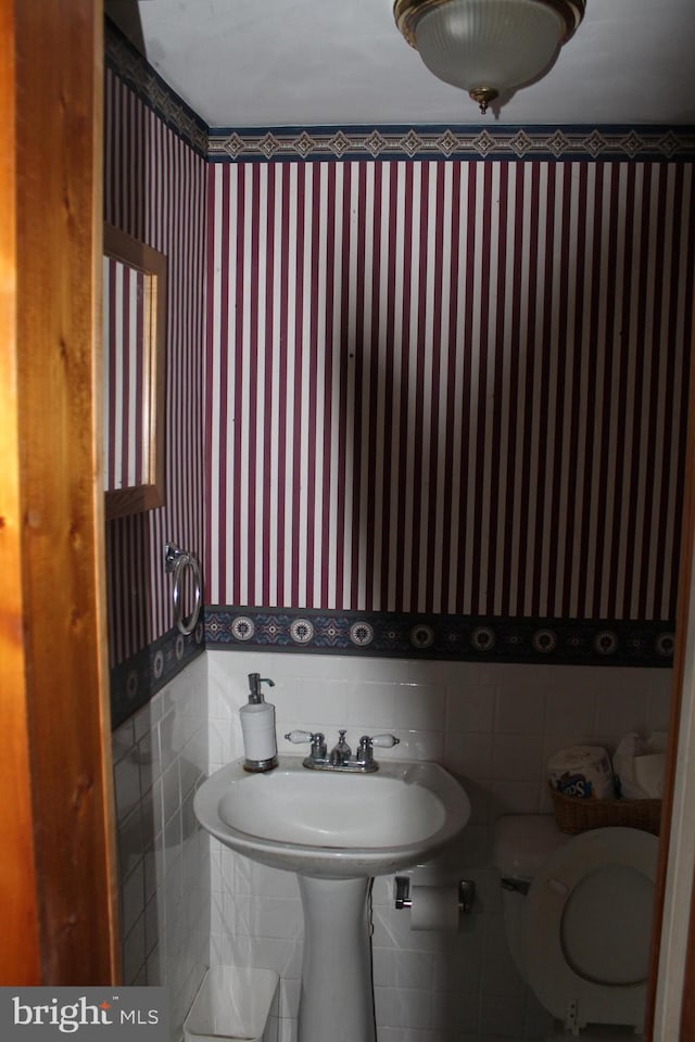 bathroom with tile walls and toilet