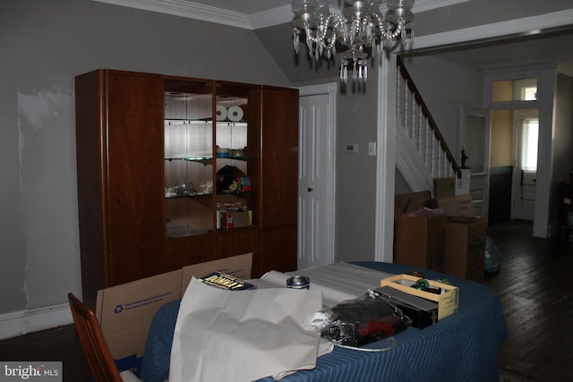 dining area with dark wood-type flooring, a chandelier, and crown molding