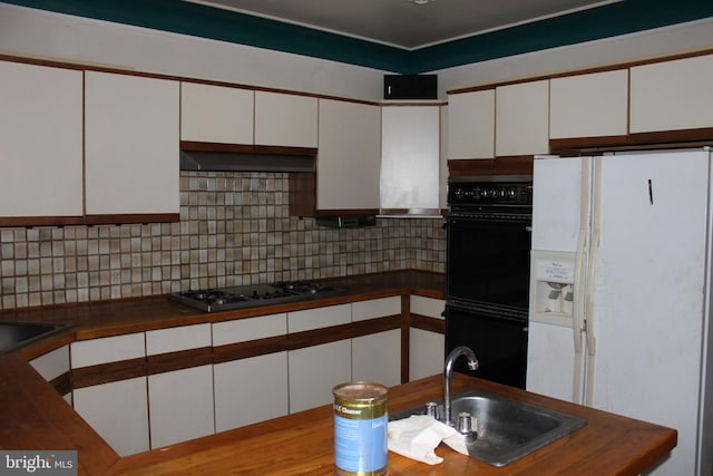 kitchen featuring white cabinetry, black double oven, stainless steel gas cooktop, white refrigerator with ice dispenser, and sink