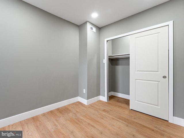 unfurnished bedroom featuring light wood-type flooring and a closet