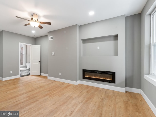 unfurnished living room featuring ceiling fan, light hardwood / wood-style floors, and a wealth of natural light