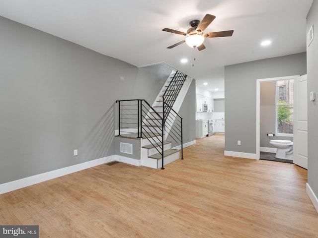 unfurnished living room with ceiling fan and light wood-type flooring