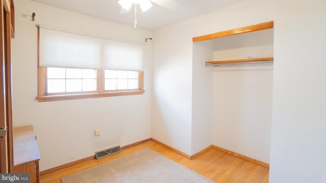 unfurnished bedroom featuring ceiling fan, light hardwood / wood-style floors, and a closet