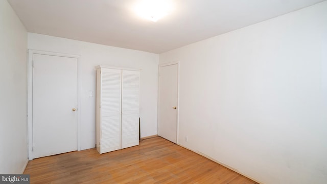 unfurnished bedroom featuring a closet and light wood-type flooring